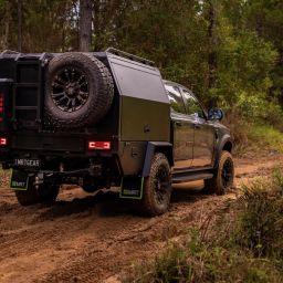 X-Series Chassis Mount Canopy black on dirt road with jerry can holder, spare wheel and ladder