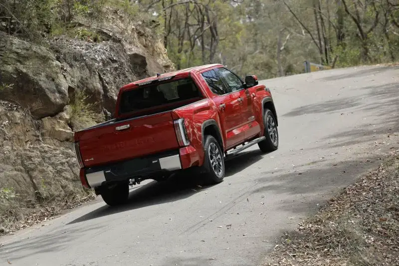 Red Toyota Tundra Driving in Australia in the bush with out a ute canopy